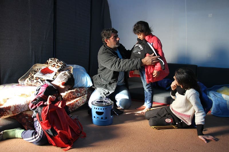 A refugee in Qushtaba camp checks a warm tracksuit - provided by Islamic Relief - for size.
